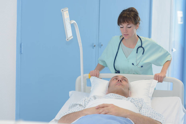 nurse wheeling patient in hospital bed - Valokuva, kuva