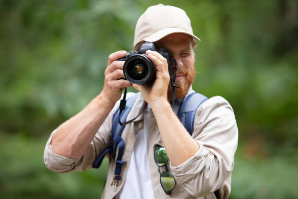 portrait of photographer taking pictures in natural landscape - Valokuva, kuva