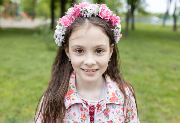 Portrait of a cute Ukrainian girl 7 years old in a flower wreath. Children want to live in peace and tranquility. Support and help Ukraine. Be proud that you are Ukrainian - Photo, Image