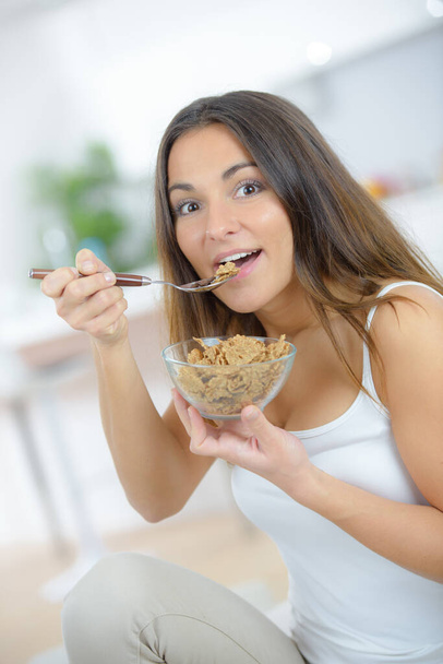 a woman is eating cereal - Φωτογραφία, εικόνα