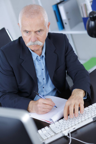 senior man in office working on laptop computer - 写真・画像