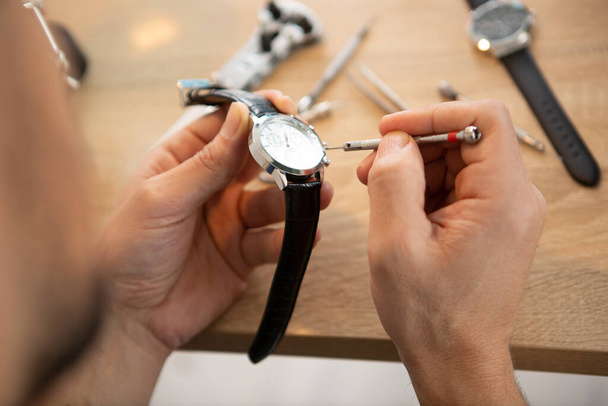 the watchmaker is repairing the mechanical watches in his workshop - Foto, imagen