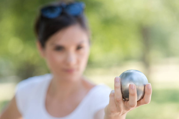 hand of woman holding petanque ball or boule - Foto, afbeelding