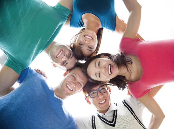 счастливая молодая студенческая группа смотрит вниз
 - Фото, изображение