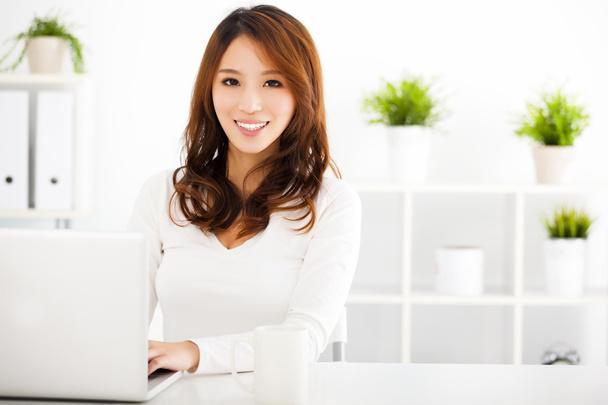 усміхнена молода азіатська жінка з ноутбуком
 - Фото, зображення