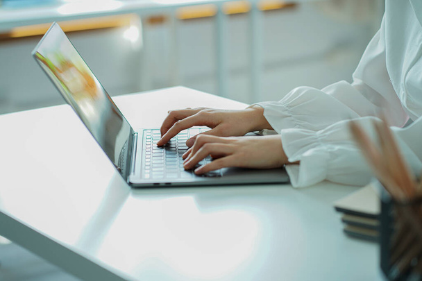 Молода жінка онлайн полювання на роботу з ноутбуком, порожній екран за столом і крупним планом робота з комп'ютерними руками
. - Фото, зображення