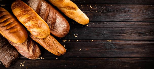 Different types of fresh crispy bread. On a wooden background. High quality photo - Фото, зображення