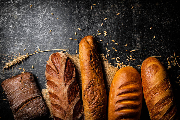 Different types of fresh homemade bread. On a black background. High quality photo - Foto, immagini