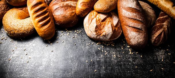 Different types of fresh homemade bread. On a black background. High quality photo - Foto, immagini
