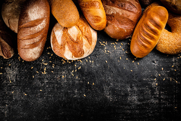 Different types of fresh homemade bread. On a black background. High quality photo - Φωτογραφία, εικόνα