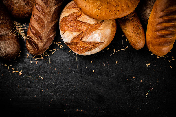 Different types of fresh bread on the table. On a black background. High quality photo - 写真・画像