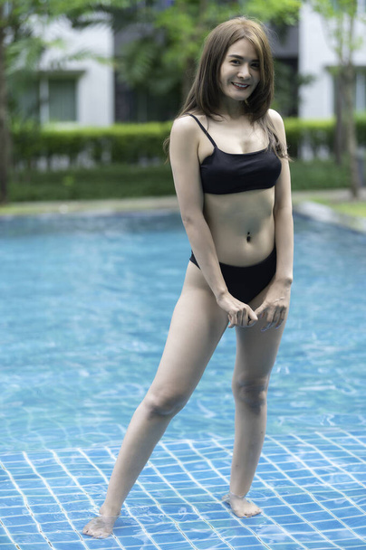 Portrait of beautiful asian woman wear bikini at the swimming pool,Summer leisure, girl relaxing in a pool - Foto, Bild