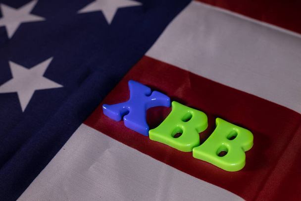 Detailed view of the word virus name XBB in letters on the background of the USA flag. Magnetic board letters. - Valokuva, kuva