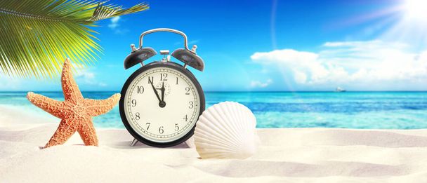 Alarm clock on seashore - beach holiday background. - Fotó, kép