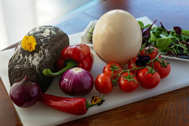 Házi kenyér, strucc tojás és zöldség, paprika, paradicsom, chili, hagyma, saláta. Összetevők omlett készítéséhez, shakshuka. Puha szelektív fókusz. - Fotó, kép