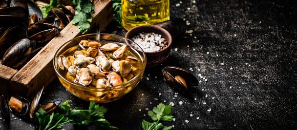 Pickled mussels with parsley and spices on the table. On a black background. High quality photo - Foto, immagini