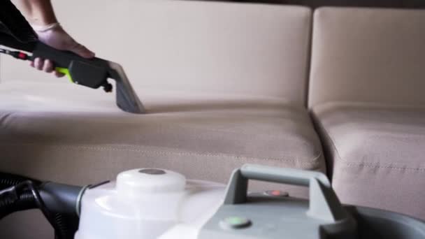 4k video cleaner is het reinigen van bank met afzuigmachine voor droog schoon gestoffeerde meubels. Huishoudster haalt vuil uit gestoffeerde bank met behulp van droogkuis extractie machine - Video