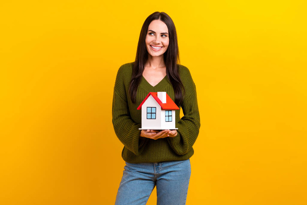Photo of positive minded girl hands hold small house look empty space isolated on yellow color background. - Фото, изображение