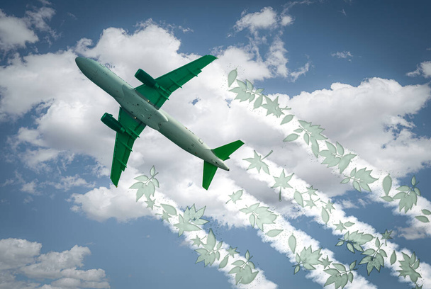 Samolot wznosi się po niebie, pozostawiając odrzutowiec z zielonymi liśćmi. Nadaje się do koncepcji takich jak emisje zerowe, SAF lub zrównoważone paliwo lotnicze, biopaliwo, gospodarka o obiegu zamkniętym i emisje netto CO2. - Zdjęcie, obraz