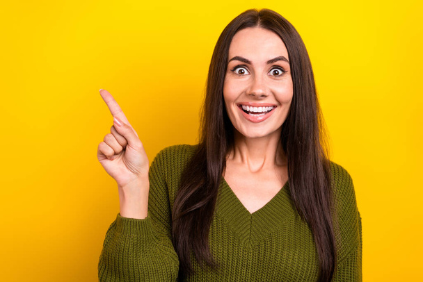 Photo of pretty cheerful person beaming smile indicate finger empty space isolated on yellow color background. - Fotografie, Obrázek