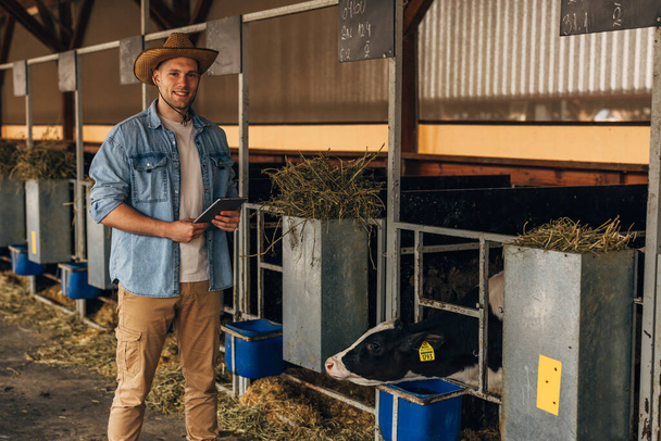 Happy countryman working at the animal farm. - Photo, image