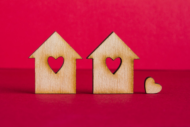 Два дерев'яні будинки з отвором у формі серця з маленькими
 - Фото, зображення