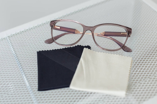 Gafas y trapo para toallitas de lentes en estante - accesorios para el concepto de gafas graduadas - Foto, imagen