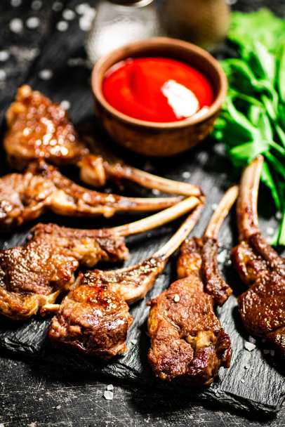 Delicious homemade grilled lamb rack. On a black background. High quality photo - Photo, Image
