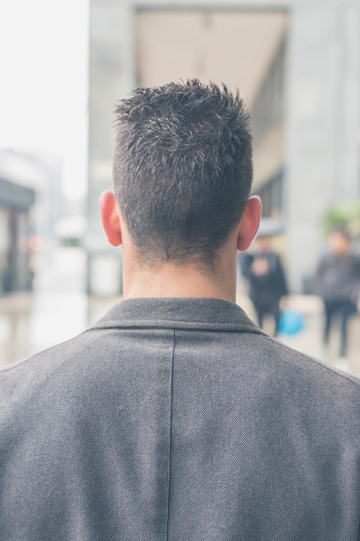 Back view of a young man posing in the city streets - 写真・画像