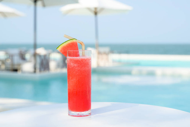 Osvěžující studený tropický melounový ovocný džus smoothie na stole s výhledem na bazén, Luxusní bazén v luxusní restauraci a hotelu, Letní dovolená u bazénu - Fotografie, Obrázek