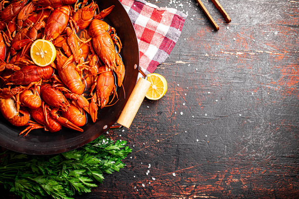 Boiled crayfish in a pot with parsley and lemon. Against a dark background. High quality photo - Фото, зображення