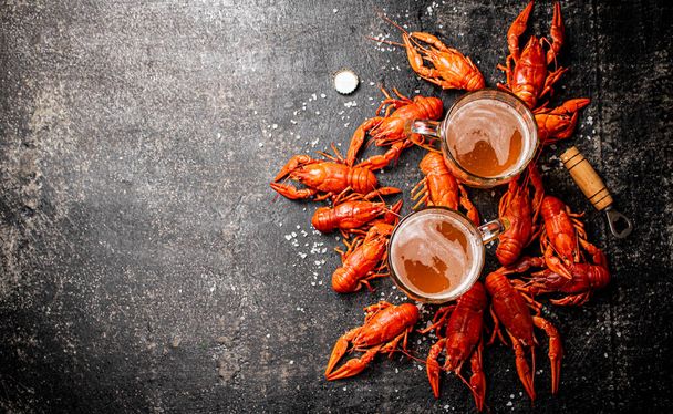 Boiled crayfish with a glass of beer. On a black background. High quality photo - Fotó, kép