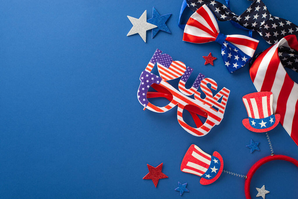 Symbolische Gegenstände für die Feierlichkeiten zum Unabhängigkeitstag von oben eingefangen: glitzernde Sterne, festliche Brillen, Stirnband, Krawatten und Fliege auf blauer Fläche mit einem freien Platz für Text oder Werbung - Foto, Bild