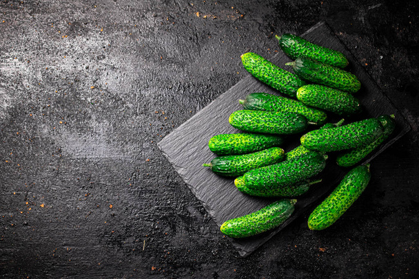 Bunch of fresh homemade cucumbers. On a black background. High quality photo - Fotografie, Obrázek