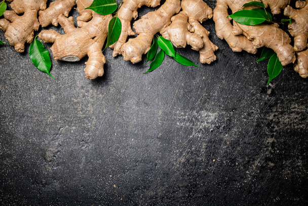Fresh ginger root with leaves. On a black background. High quality photo - Foto, Imagen