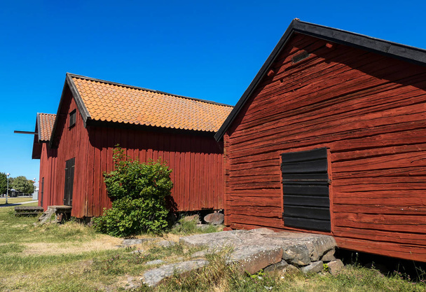 Low angle view of barn against clear blue sky - 写真・画像