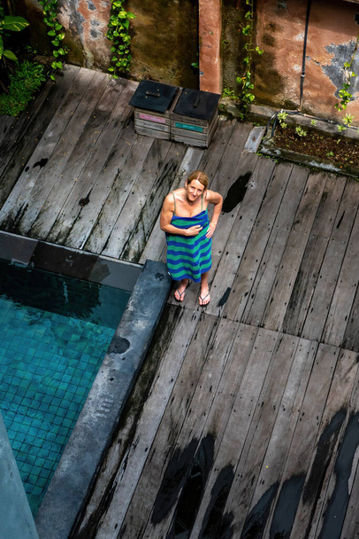 Bali, Indonesia A woman stands by the pool with a towel - Valokuva, kuva