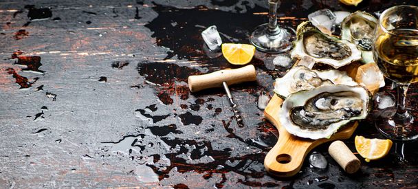 Oysters on a wooden cutting board. On a rustic dark damp background. High quality photo - Foto, Imagen