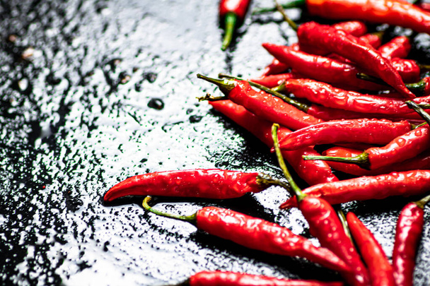 Pods of hot chili peppers on the table. On a black background. High quality photo - Valokuva, kuva