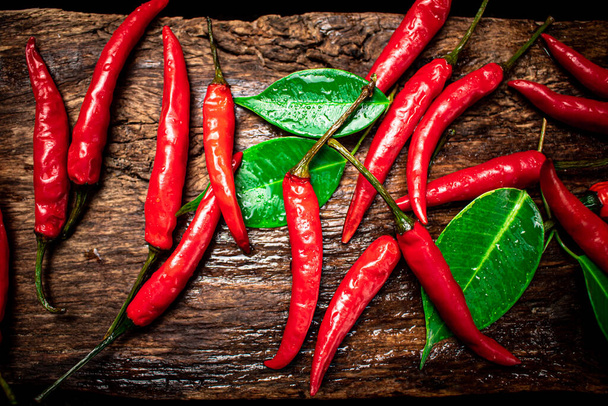 Chili peppers on the table. On a wooden background. High quality photo - Foto, imagen