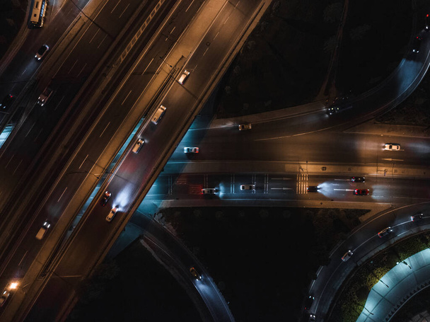 Top view of car traffic transport on crossing multiple lanes highway or expressway in Asia city at night. Civil engineering, technology background, Asian transportation concept - Fotografie, Obrázek
