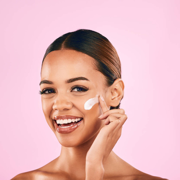 Happy woman, portrait smile and skincare cream for beauty moisturizer against a pink studio background. Female person or model smiling in happiness for lotion, cosmetic products or facial treatment. - Foto, imagen