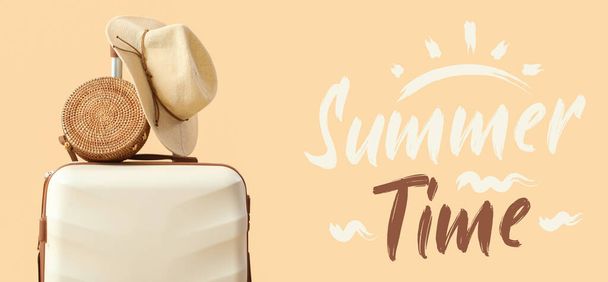 Suitcase with beach hat and bag on beige background. Summer time - Photo, Image