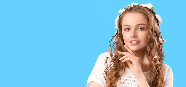 Красива молода жінка з квітами у волоссі на світло-блакитному тлі з місцем для тексту. Літнє сонцестояння
 - Фото, зображення