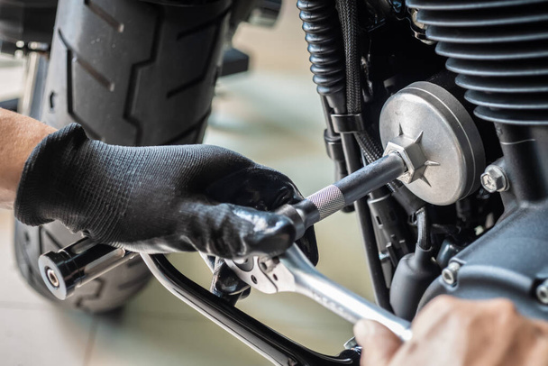 mechanik použití olej filtr klíč nástroj na motocykl v garáži, koncept údržby a opravy motocyklů. selektivní zaměření - Fotografie, Obrázek