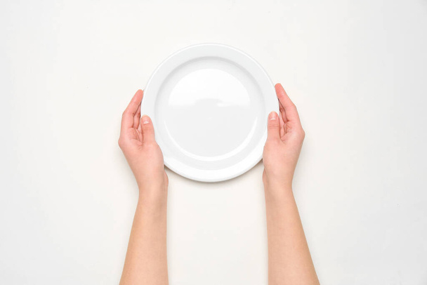Ženské ruce s prázdným talířem na bílém pozadí - Fotografie, Obrázek