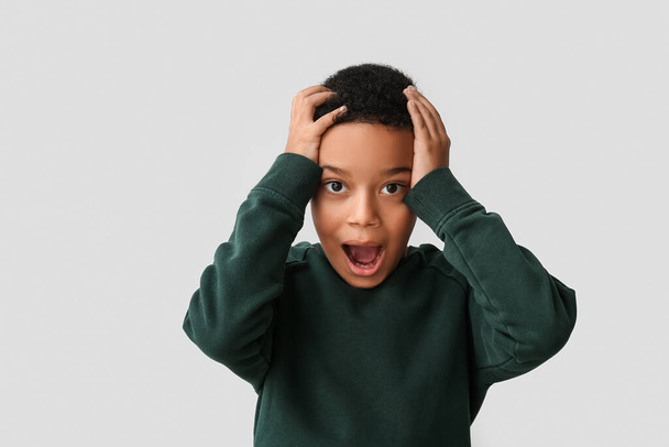 Scared little African-American boy on light background - Foto, afbeelding