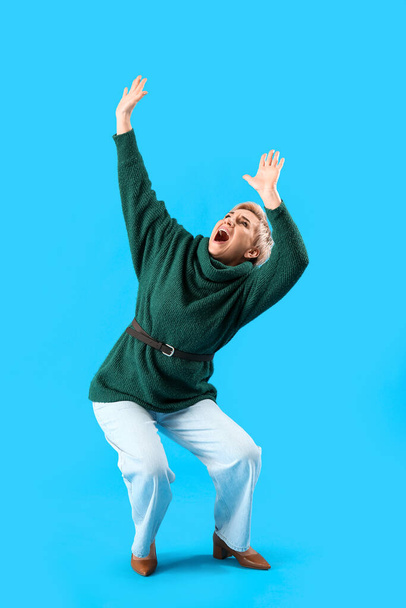 Scared mature woman on light blue background - Photo, Image