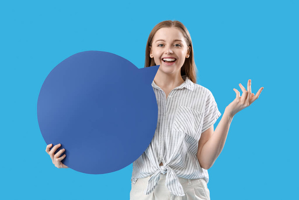Happy young woman with blank speech bubble on blue background - Foto, Bild