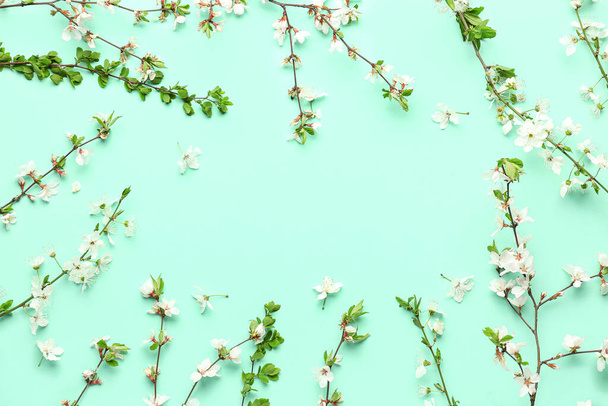 Rámeček z kvetoucích větví stromů s bílými květy na tyrkysovém pozadí - Fotografie, Obrázek